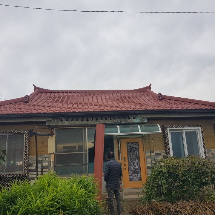 오래된 농가 단독주택에 화사한 적색 기와형 칼라강판 지붕을 시공 완료한 사진
